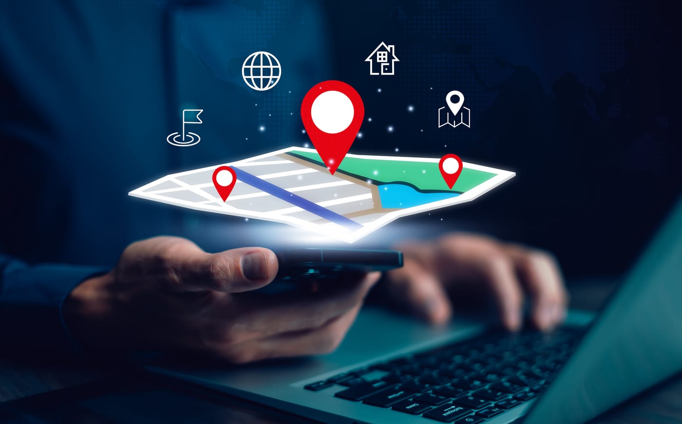 Mains manipulant smartphone et clavier d'ordinateur, avec carte GPS lumineuse et icônes de localisation en surimpression